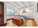 Bedroom with wood floors, beamed ceilings, and a chest at the foot of the bed at 740 Carr St, Lakewood, CO 80214