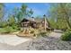 Landscaped yard surrounding a charming home with stone accents, a welcoming porch, and mature trees at 740 Carr St, Lakewood, CO 80214