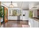 Bright, open kitchen with white cabinets, stone countertops, stainless steel appliances, and terra cotta floors at 740 Carr St, Lakewood, CO 80214