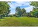Expansive backyard featuring lush lawn, mature trees, and a charming treehouse deck at 1315 Tipperary St, Boulder, CO 80303