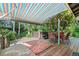 Backyard deck featuring a hot tub, seating, and awning, surrounded by beautiful plants and trees at 1315 Tipperary St, Boulder, CO 80303