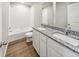 Bathroom with double vanity, granite countertop, and combination shower and tub at 2120 Christina St, Fort Lupton, CO 80621