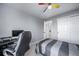 Cozy bedroom with soft gray walls, closet, ceiling fan with colorfully painted blades and a desk at 9505 Painted Canyon Cir, Highlands Ranch, CO 80129