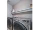 Convenient laundry room with modern washer and dryer units and built in shelving at 9505 Painted Canyon Cir, Highlands Ranch, CO 80129
