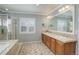 Bright bathroom with double sinks, large mirror, and shower with glass door at 14032 Park Cove Dr, Broomfield, CO 80023