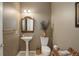 Cozy powder room featuring a pedestal sink, decorative mirror, and neutral color scheme at 14032 Park Cove Dr, Broomfield, CO 80023