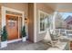 Inviting front porch with rocking chairs, potted plants, and a stylish front door with a wreath at 14032 Park Cove Dr, Broomfield, CO 80023