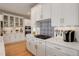 Modern kitchen featuring white cabinets, stainless steel appliances, and stylish blue backsplash at 14032 Park Cove Dr, Broomfield, CO 80023