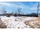 Large, partially fenced backyard with snow at 6661 Clermont St, Commerce City, CO 80022