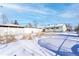 Large backyard with snow, partially fenced at 6661 Clermont St, Commerce City, CO 80022