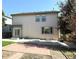 View of a two-story home featuring a backyard patio and lush green grass on a sunny day at 20401 E Chenango Pl, Aurora, CO 80015