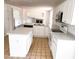Bright kitchen with white cabinetry, white appliances and a kitchen island at 20401 E Chenango Pl, Aurora, CO 80015
