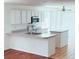 Bright kitchen featuring white cabinetry, breakfast bar and stainless appliances at 20401 E Chenango Pl, Aurora, CO 80015