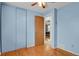 Bedroom features blue walls, hardwood floors and an open doorway to another room at 9135 Bellaire St, Thornton, CO 80229
