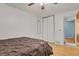 Bedroom features bed with decorative headboard, sliding closet doors, and hardwood floors at 9135 Bellaire St, Thornton, CO 80229