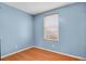 Bedroom with blue walls, wood floors, and natural light from a large window at 9135 Bellaire St, Thornton, CO 80229