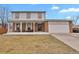 Charming two-story home featuring a brick facade, covered porch with benches, and an attached two-car garage at 9135 Bellaire St, Thornton, CO 80229