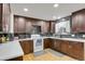 View of kitchen with dark cabinetry, white counters, stainless appliances, and black marble accent backsplash at 9135 Bellaire St, Thornton, CO 80229