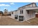 This backyard features neutral siding, black trim, a stone paver patio, a grill, and an old tire stack at 9135 Bellaire St, Thornton, CO 80229