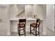 Basement wet bar with two bar stools and a view of the staircase at 12804 Fisher Dr, Englewood, CO 80112