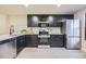 Well-equipped kitchen featuring stainless steel appliances, dark cabinetry, and modern countertops at 624 S Depew St # C, Lakewood, CO 80226