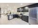 Stylish kitchen boasts stainless steel appliances, dark cabinetry, and an open layout connected to the living area at 624 S Depew St # C, Lakewood, CO 80226