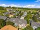 A residential neighborhood with neat rows of townhomes, mature trees, and landscaped yards from an aerial perspective at 6813 W Yale Ave, Lakewood, CO 80227