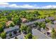 Expansive aerial view of a residential neighborhood nestled amongst mature trees and green spaces with mountain views at 6813 W Yale Ave, Lakewood, CO 80227