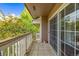 A cozy balcony with sliding glass doors, a white railing, and a serene outdoor view with flourishing trees at 6813 W Yale Ave, Lakewood, CO 80227
