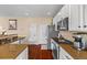 Functional kitchen area with white cabinets, stainless steel appliances, and dark wooden floors at 6813 W Yale Ave, Lakewood, CO 80227