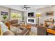 Comfortable living room featuring a modern fireplace, TV, ceiling fan, and plenty of natural light at 6813 W Yale Ave, Lakewood, CO 80227