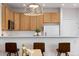 Open kitchen with bar seating, wooden cabinets, and modern appliances at 8251 W 54Th Ave # 4, Arvada, CO 80002