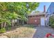 Landscaped backyard with brick building and gravel area at 2303 - 2305 W 32Nd Ave, Denver, CO 80211