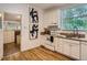 White kitchen with hardwood floors and stainless steel appliances at 2303 - 2305 W 32Nd Ave, Denver, CO 80211