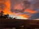 Lovely backyard with landscaping and distant windmill against an orange sunset sky at 575 Howling Cir, Elizabeth, CO 80107
