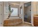 Modern bathroom featuring a glass shower and a soaking tub under a window at 575 Howling Cir, Elizabeth, CO 80107