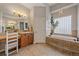 Modern bathroom featuring a soaking tub under a window, tile floors and double vanity at 575 Howling Cir, Elizabeth, CO 80107