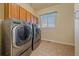 Well-equipped laundry room featuring a front loading washer and dryer, with tile floor at 575 Howling Cir, Elizabeth, CO 80107