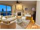 Staged living room featuring a tile fireplace, hardwood floors and lots of light at 575 Howling Cir, Elizabeth, CO 80107