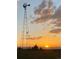 An old windmill silhouetted by the sunset against a backdrop of golden, wispy clouds at 575 Howling Cir, Elizabeth, CO 80107