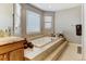 Luxurious bathroom featuring a large jacuzzi tub, windows, and a double vanity at 5895 E Conservation Dr, Frederick, CO 80504