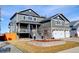 Gray two-story home with stone accents, landscaped yard, and covered porch at 5895 E Conservation Dr, Frederick, CO 80504