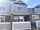 Inviting townhome featuring stone accents, blue siding, and a well-manicured front yard at 23465 E Platte Dr # C, Aurora, CO 80016