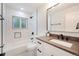 Updated bathroom with a modern vanity, a white tiled shower/tub, and black accents at 6220 E 5Th Ave, Denver, CO 80220