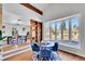 The dining area has a bay window and modern blue chairs centered around a round table at 6220 E 5Th Ave, Denver, CO 80220