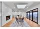 Open dining room with a cozy fireplace, skylight, and sliding glass doors to an outdoor patio at 6220 E 5Th Ave, Denver, CO 80220