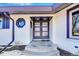 Welcoming front entrance featuring a modern door with glass panels, a small porch with a step, and contemporary architectural details at 6220 E 5Th Ave, Denver, CO 80220