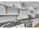 Gourmet kitchen with stainless steel stove, open cabinets and modern tile backsplash at 6220 E 5Th Ave, Denver, CO 80220