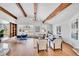 Bright living room with vaulted ceilings, exposed beams, hardwood floors, and large windows allowing natural light to flood the room at 6220 E 5Th Ave, Denver, CO 80220
