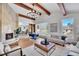 Spacious living room boasts a fireplace, hardwood floors, and exposed ceiling beams at 6220 E 5Th Ave, Denver, CO 80220